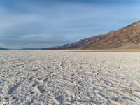 the vast landscape of a dry lake on a bright summer day with sparse sand covering the entire area