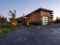 this is a driveway in the middle of a large wooden home with glass doors and an outdoor bench