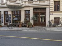 two bikes parked outside of a restaurant next to a street corner on a city sidewalk