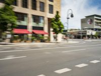 the man rides his moped in the city streets alone of traffic and the street light has blurred to the left