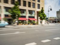 the man rides his moped in the city streets alone of traffic and the street light has blurred to the left