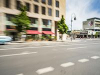 the man rides his moped in the city streets alone of traffic and the street light has blurred to the left