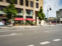 the man rides his moped in the city streets alone of traffic and the street light has blurred to the left