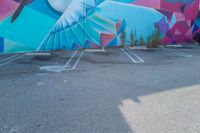 the parking lot is adorned with colorful street art like a humming bird, and features a geometric design