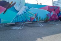 the parking lot is adorned with colorful street art like a humming bird, and features a geometric design