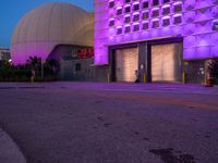 the building is illuminated purple on a blue and purple night time sky in las, nevada