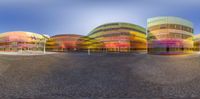 several buildings on the side of a road with many light coming in from them to bright red yellow and blue colors