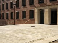 the courtyard of a building in an urban neighborhood is empty with cars parked in the distance