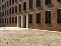 the courtyard of a building in an urban neighborhood is empty with cars parked in the distance