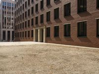 the courtyard of a building in an urban neighborhood is empty with cars parked in the distance