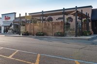 a store front with wood privacy screens and a car parked outside it, on the street side