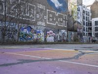 a basketball court in front of a building has graffiti on it with the words'harlem alley all over the wall