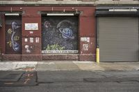an old building is covered in graffiti and graffiti paper on the side of it, with a fire hydrant, street signs, trash cans and a fire hydrant, some windows and a curb, and a black trash can all