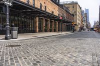 there is a street with brick walkways on both sides of it and some tall buildings behind it