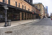 there is a street with brick walkways on both sides of it and some tall buildings behind it