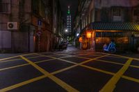 the street at night is lit up with traffic lights and the buildings are brightly lit