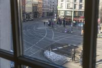 there is a view out the window at an intersection from inside a building in a city