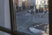 there is a view out the window at an intersection from inside a building in a city