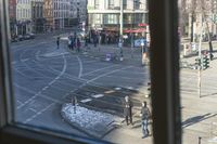there is a view out the window at an intersection from inside a building in a city