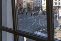 there is a view out the window at an intersection from inside a building in a city