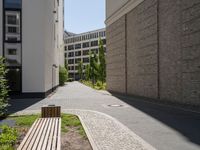 there are buildings along this side walk and one sidewalk in the opposite lane in the middle