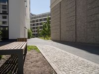 there are buildings along this side walk and one sidewalk in the opposite lane in the middle