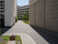 there are buildings along this side walk and one sidewalk in the opposite lane in the middle