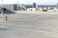 two people in parking lot looking down at city skyline in distance in foreground area