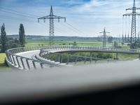 view out the window on an elevated roadway with power lines in the distance on a sunny day