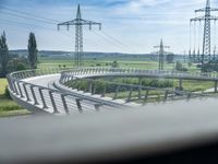 view out the window on an elevated roadway with power lines in the distance on a sunny day