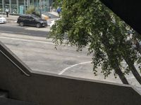 a view looking out from an indoor elevator into a parking lot with cars passing by