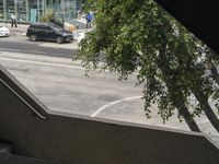 a view looking out from an indoor elevator into a parking lot with cars passing by