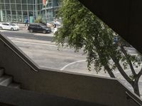 a view looking out from an indoor elevator into a parking lot with cars passing by