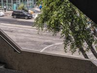 a view looking out from an indoor elevator into a parking lot with cars passing by