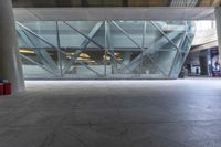 the view from the outside of a building through a glass walkway of a red suitcase