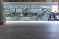 the view from the outside of a building through a glass walkway of a red suitcase
