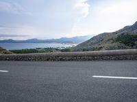 a person on a bike is going down a steep hill overlooking a bay and mountains