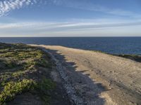 a view of a large body of water with a path leading to the beach and sky