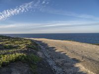 a view of a large body of water with a path leading to the beach and sky