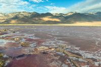 a view of the vast, pink colored ground at the bottom of a desert plain