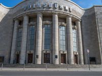 an entrance of a building with large columns and doors that spell out the word voltege