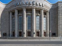 an entrance of a building with large columns and doors that spell out the word voltege