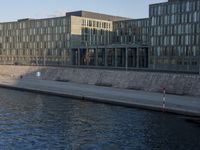 the people are walking along the side of the canal in the water near some buildings