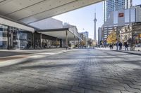 people walk down a walkway in downtown toronto, ontario, canada on a bright sunny day