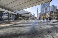 people walk down a walkway in downtown toronto, ontario, canada on a bright sunny day