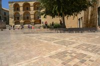 a person is walking down the street with an umbrella on an empty brick pavement in a stone courtyard