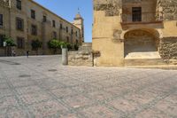 a person is walking down the street with an umbrella on an empty brick pavement in a stone courtyard