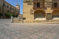 a person is walking down the street with an umbrella on an empty brick pavement in a stone courtyard