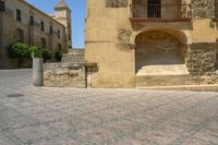 a person is walking down the street with an umbrella on an empty brick pavement in a stone courtyard