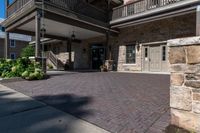 a walkway leading to the front door of a home with some landscaping around it, and two balconies in the background